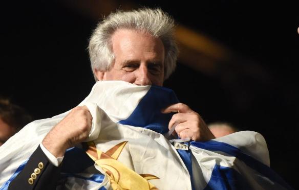 Presidential candidate for the ruling Broad Front party Tabare Vazquez kisses a Uruguya's flag as he celebrates in Montevideo, Uruguay Sunday, Nov. 30, 2014. Exits polls shows that Broad Front coalition candidate and former president Tabare Vazquez has won the presidential elections.(AP Photo/Matilde Campodonico)